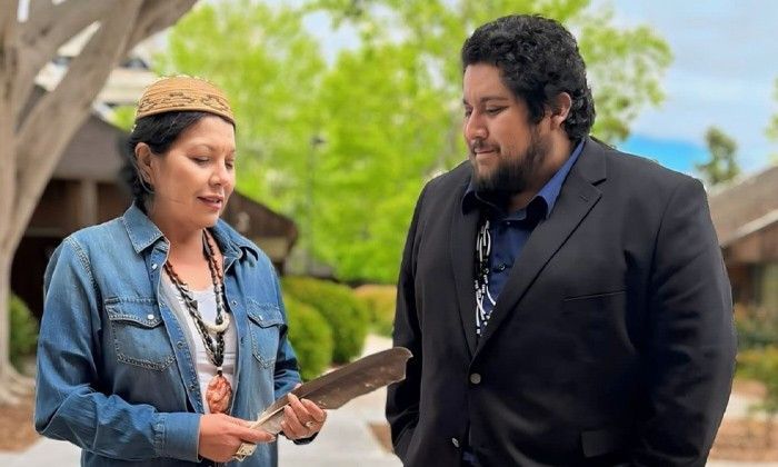Tishmall Turner presenting an eagle feather to Dr. Alec Calac