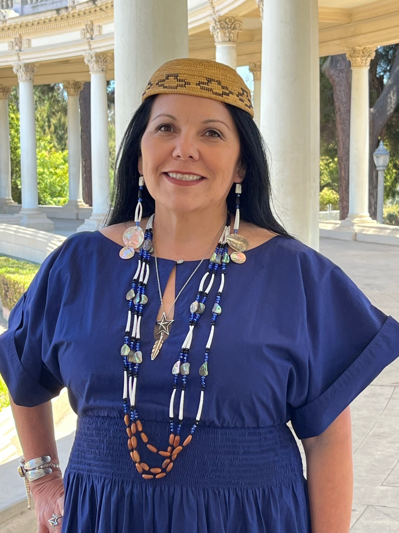 Tishmall Turner wearing a blue dress and traditional regalia