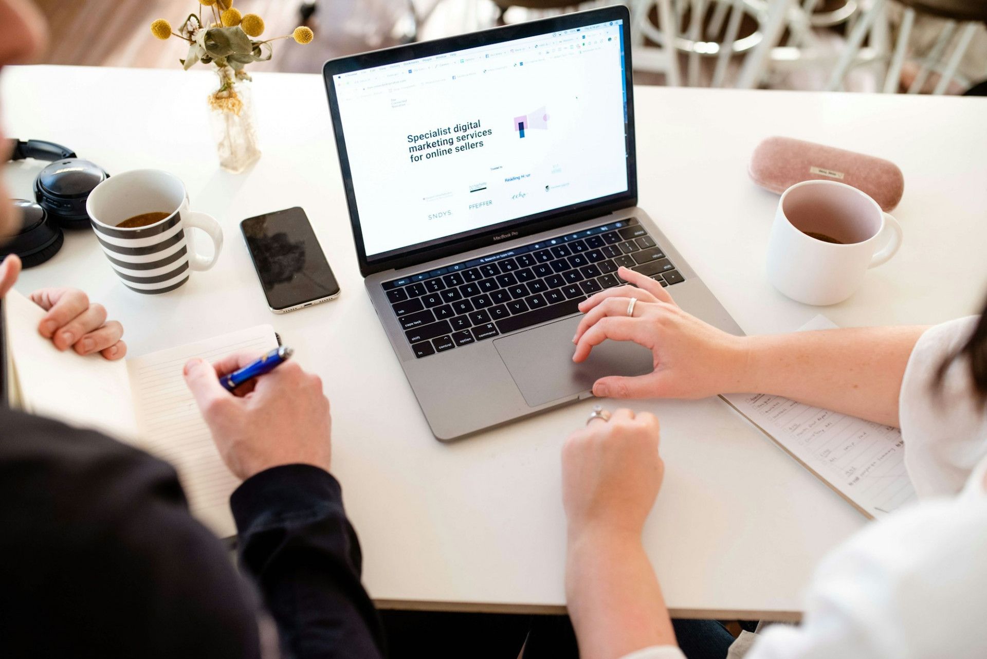 Two people reviewing a website together on a laptop