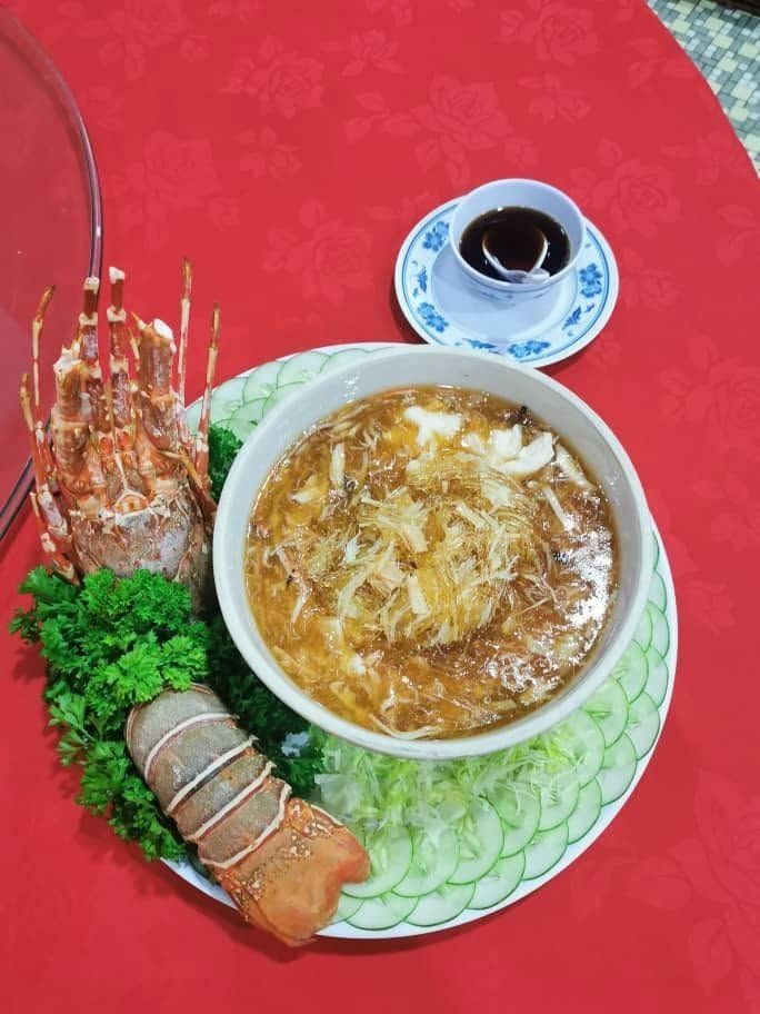 Lobster with a bowl of thick soup on a round banquet table · 圆桌宴席上的龙虾与浓汤
