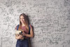 Mathematics in everyday life, woman standing in front of a chalkboard with equations