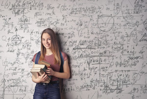 Mathematics in everyday life, woman standing in front of a chalkboard with equations