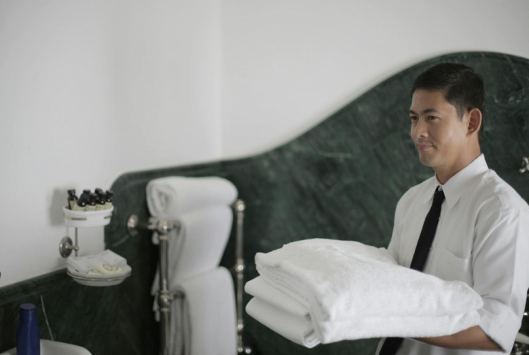 a hotel worker carrying a stack of towels